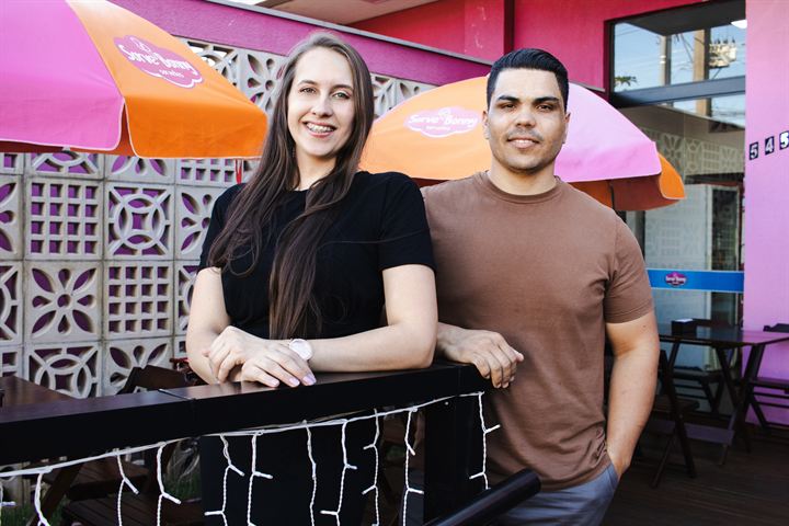 Rangel e Dalília, o Casal do Sorvete, sorrindo na varanda da Sorvebonny, com guarda-sóis da marca ao fundo
